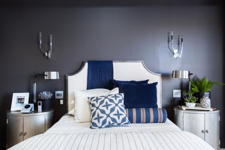 Master bedroom's queen bed has gunmetal frame and blue accent pillows