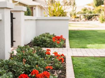 Even the most basic flower bed will look fantastic when properly edged. Clean lines and simple pops of color help boost this home’s entry 100%.