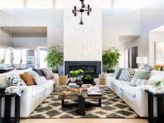 Comfortable white sofas sit on either side of a charcoal area rug