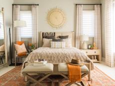 This welcoming guest suite with vibrant bursts of orange accents and earthen design details creates a relaxing retreat for visitors.