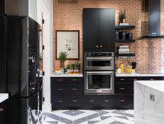 Defined by bold black cabinetry and oversized light fixtures, the high-tech kitchen offers space for both food prep and entertaining.