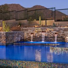 Double Layer Retaining Wall With Natural Rock Pool Surround Featuring Built In Waterfall and Holographic Pool Tile 