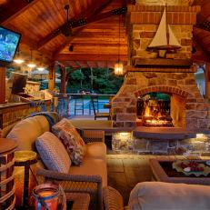 Outdoor Pavilion Living Space With Stone Fireplace Chimney, Comfortable Seating and Mounted Television