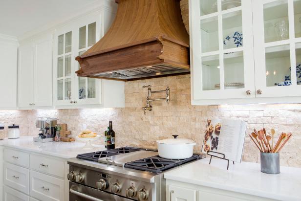 White Kitchen With Natural Stone Backsplash and Wood Range Hood