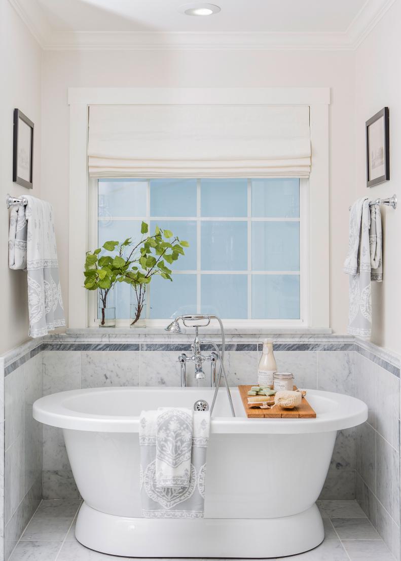 Bathroom With Pedestal Bathtub and Gray and White Marble Tile
