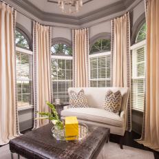 Warm, Gold-Infused Sitting Area Tucked Into Bay Window