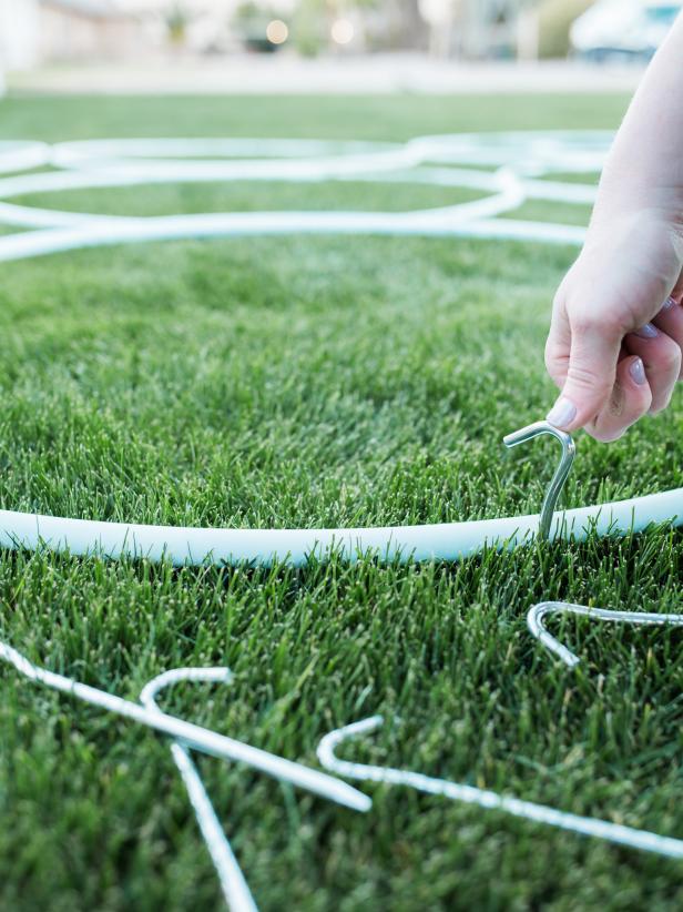 Step 6- Secure Hoops 
Once hoops are dry to the touch, secure them into the grass with tent hooks. Use a minimum of two hooks for each hoop.
