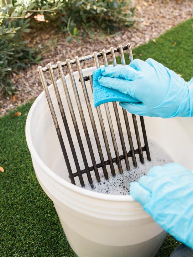 Step 5- Soak Grates
Turn off the grill. Once the grates are cool to the touch, remove them and place into a bucket of warm sudsy water. Soak the grates for a few hours. Scrub any excess grime off the grates using a scouring sponge.