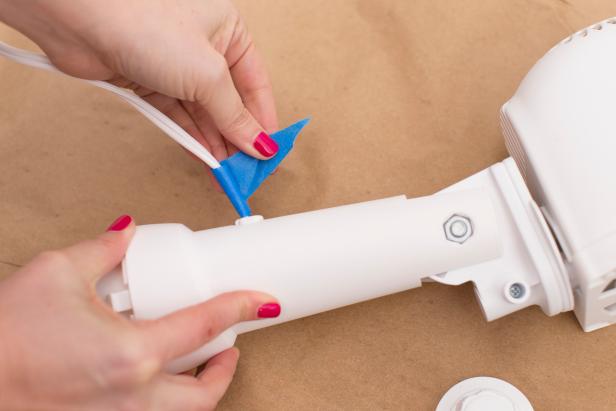 Tape the fan's cord to protect it from the spray paint.