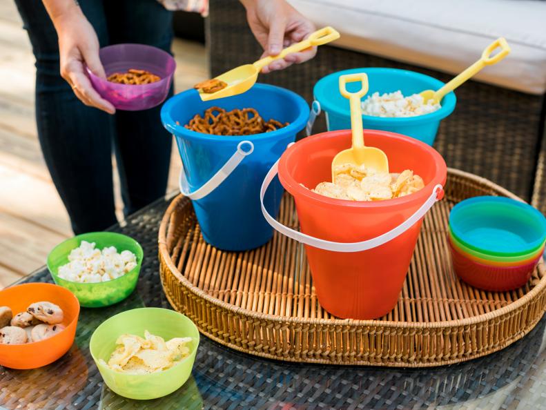 BUCKET SNACK HOLDERS
Skip the breakable bowls and platters and just serve snacks in colorful plastic buckets that kids will love. BONUS- you can send them home with the little guests after the party for super easy clean up!