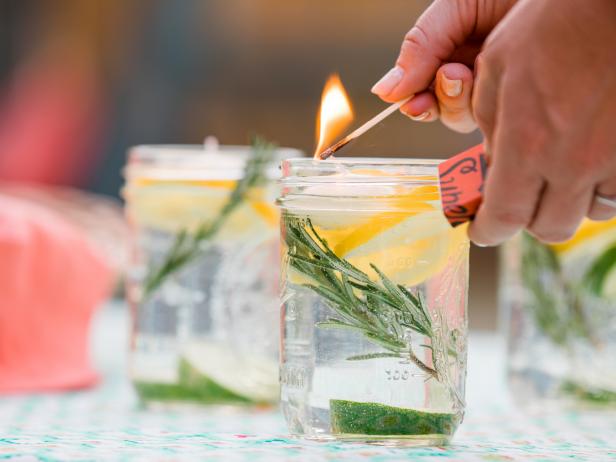BUG REPELLANT LUMINARIES
If the idea of dousing your yard in bug spray before a kids’ party just turns your stomach, whip up a few of these luminaries to keep mosquitos from crashing your party. Place a few slices of lemons and limes along with sprigs of rosemary into a jar of water, then add several drops of essential oil. We recommend citronella, lemon or lavender! Top with a floating candle and you’re good to go!