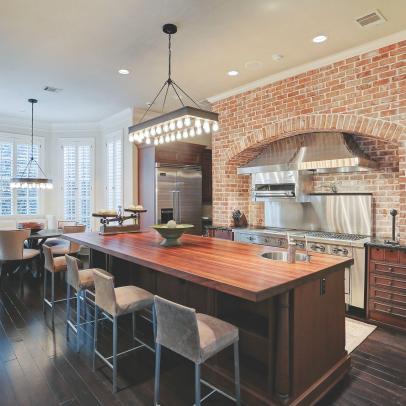 Chef Kitchen With Barstools and Brick Wall