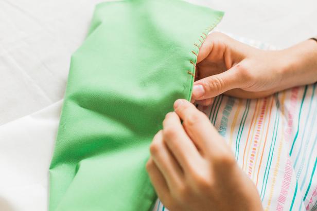 Using a contrasting thread, use a simple whip or blanket stitch to secure the pillow cases to each other. Make sure the open ends of the pillow cases all face in the same direction. 