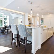 White Kitchen With Large Central Island and Breakfast Nook