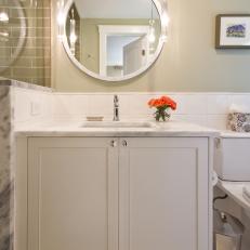 Neutral Guest Bathroom With Single Vanity and Round Mirror