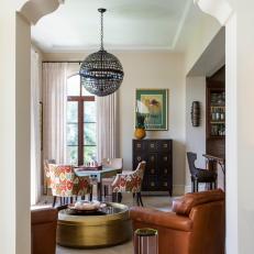 Eclectic Sitting Room With Globe Chandelier and Brown Leather Armchairs