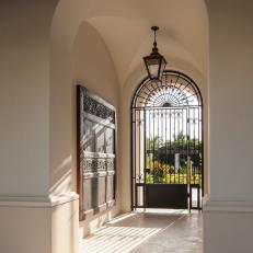 Mediterranean Courtyard Entry With Arched Doorway and Wrought Iron Gate