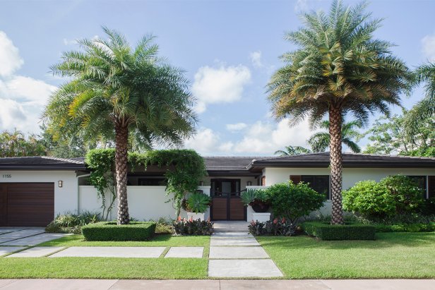 Ranch Style Home With White Stucco Exterior and Palm Tree Landscaping