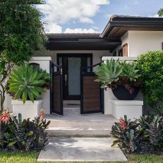 Ranch Style Home With White Stucco Exterior and Gated Entrance