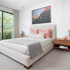 Contemporary Master Bedroom With Floating Nightstands and Orange Accents