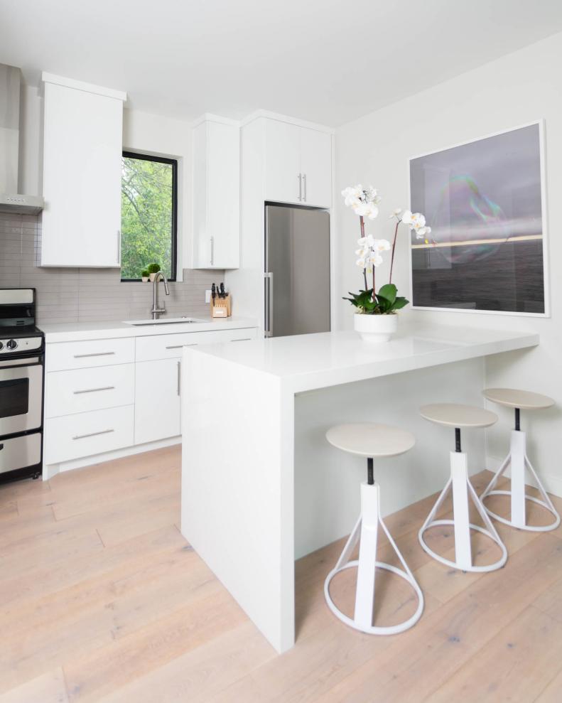 White Kitchen With Natural Hardwood Floors and Gray Tile Backsplash