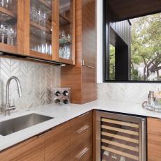 Stylish Butler's Pantry With Glass Front Cabinets and a Metallic Tile Backsplash