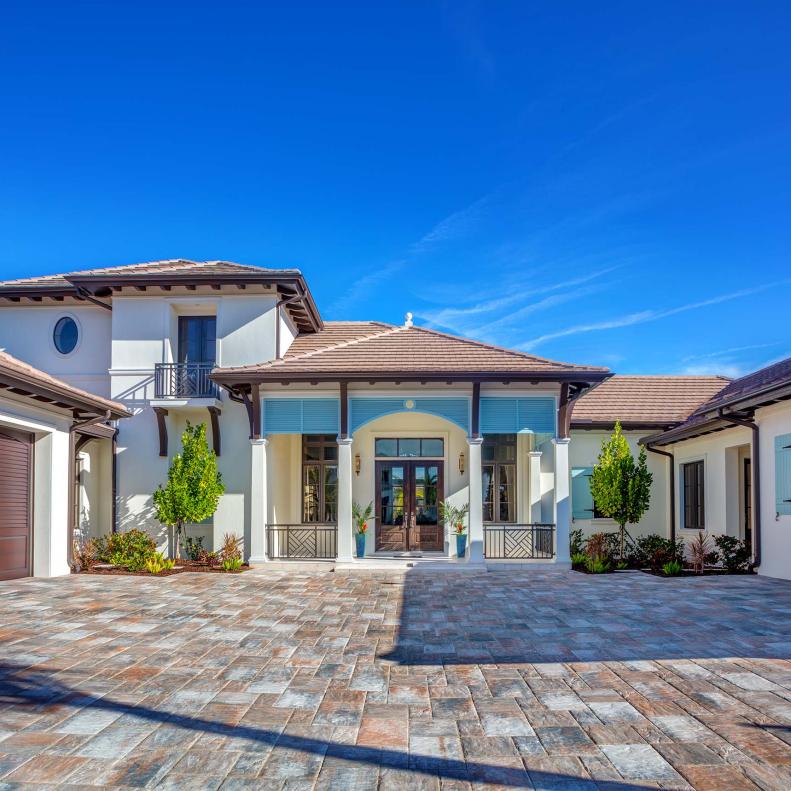 Neutral Home Exterior With Paver Stone Driveway and Spanish Tile Roof