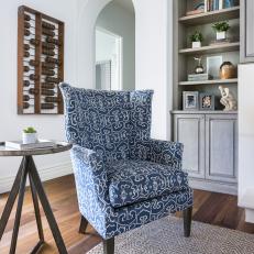 Transitional Family Room With Bold Blue Armchair and Built-In Bookshelves