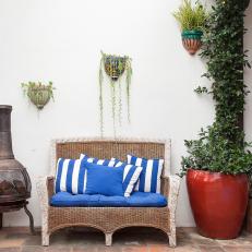 Patio With Blue Loveseat and Red Pot