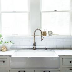 Farmhouse Sink and White Pendant Light in Remodeled Kitchen
