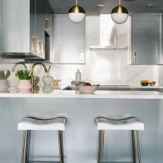 Modern Gray Kitchen With Pendant Lights and White Barstools