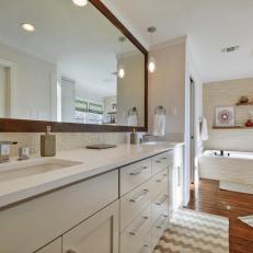 White Bathroom With Double Vanity and Chevron Rug