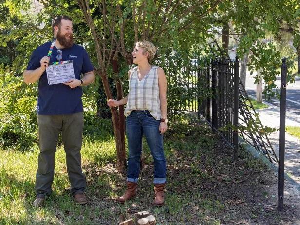 As seen on Home Town, Ben and Erin Napier (C) goof around outside with the slate board before working on the next scene in the front exterior of the Walker residence. Cameraman James Duhon (R) prepares to film the scene. (behind the scenes)