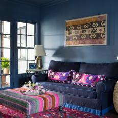 Blue Sitting Room With Bright and Colorful Pillows, Coffee Table and Rug 