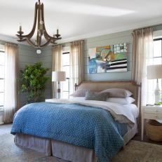 Cozy Country Neutral Bedroom With Petal Light Fixture, Shiplap Walls and Blue Comforter