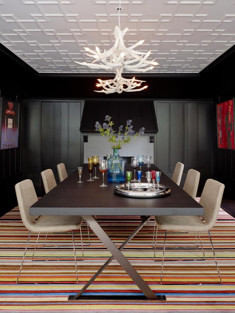 Black Dining Room With Striped Rug and Antler Chandeliers