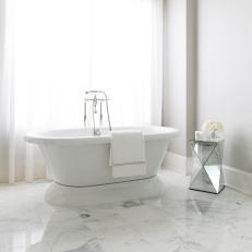 Free Standing Tub in Master Bathroom With Marble Tile Flooring