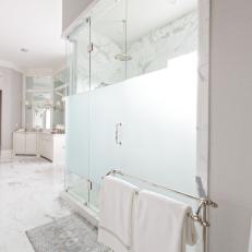 Standing Shower With Marble Tiling and Frosted Glass Panel