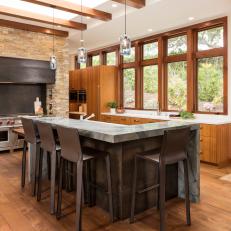 Warm Wood Transitional Kitchen With Stone Range Frame, Pendant Lights and Contemporary Island