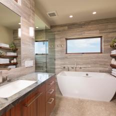 Master Bathroom With Modern White Tub, Floating Shelves and Stone Finishes