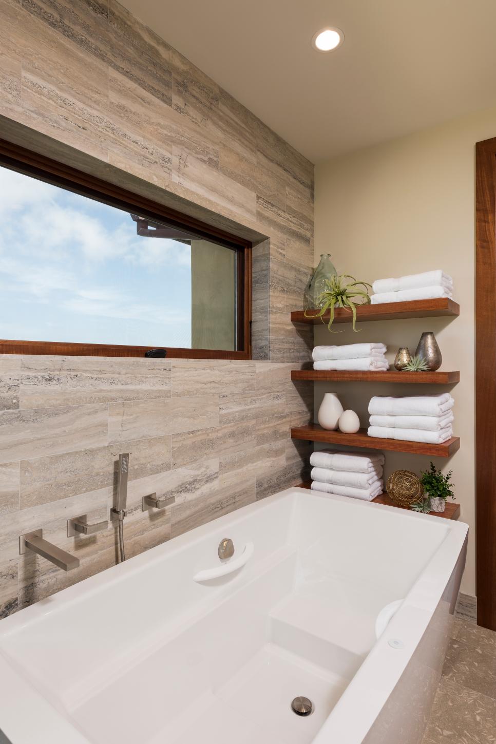 Modern Floating Shelves Over White Bathtub With Neutral Travertine Wall