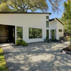 Modern Home With White Exterior, Gravel Driveway and Bamboo Planter 