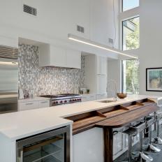 Small Tile Backsplash and Long Modern Island in Bright, White Kitchen 