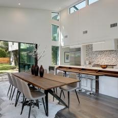 Modern Dining and Kitchen Space With Butcher Block Island and Leather Dining Chairs