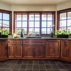Kitchen Bay Window With Built in Walnut Cabinets, Glazed Tile Floor and Countertop Plant Display