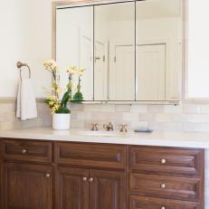 Traditional Bathroom Vanity With Three-Panel Mirror, Wood Cabinetry and Tile Backsplash Strip