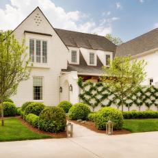 White Home Exterior With Dormer Windows and Pear Tree Espalier