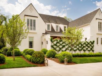 White Home Exterior With Dormer Windows and Espalier on Wall