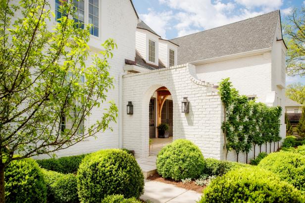 White Home Exterior With Landscaping and Brick Archway