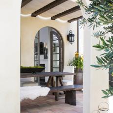 Covered Patio With Arched Doorway and Exposed Ceiling Beams